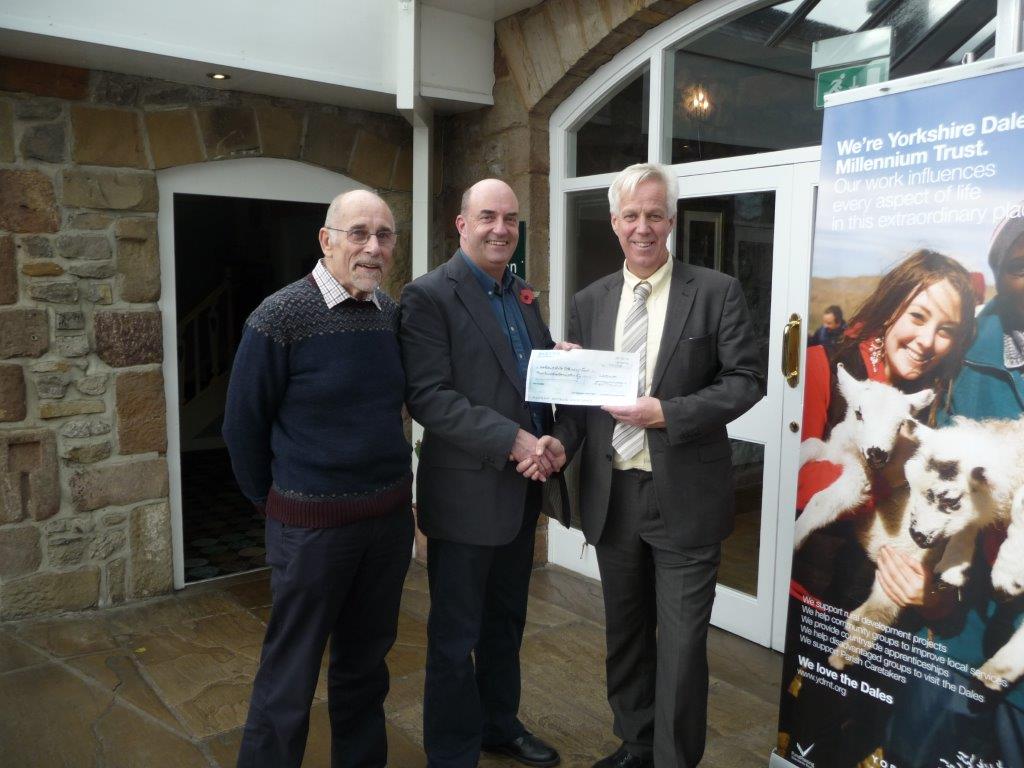 YDMT Director David Sharrod is presented with a cheque for £400 by Alan Poxon and Peter McCormick from Gargrave Art & Crafts