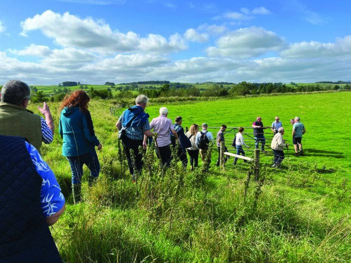 Celebration event attendees walking the Long Preston floodplain